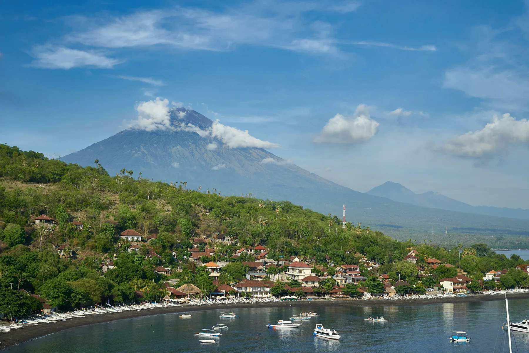 Traditional boats at Amed beneath Mount Agung, illustrating the Bali coast.